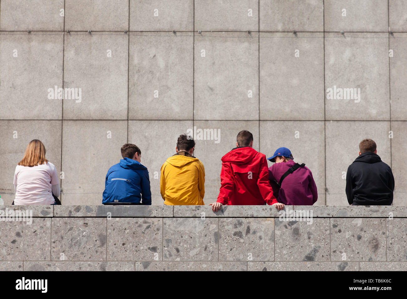 Les jeunes gens assis sur un mur au musée romain-germanique, Cologne, Allemagne. Jugendliche sitzen auf einer Mauer am Roemisch-Germanischen Museum, Ko Banque D'Images
