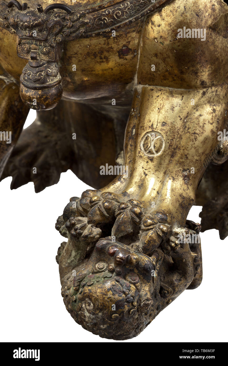 Une lionne en bronze doré (bouddhiste gardien lion) - la dynastie Qing, xviiie siècle, en bronze doré, incendie, marqués et gravés. La créature mythique superbement travaillé assis sur ses pattes arrières, la tête couverte d'une épaisse crinière de boucles dix, le corps robuste également recouvert de fourrure, le visage avec une expression sauvage, sa bouche grande ouverte pour révéler bared les dents, au-dessus duquel yeux exorbités et sourcils broussailleux, une cloche et glands suspendus à un ruban noué autour de la large poitrine, la patte gauche interdisant à son petit sur le terrain. Les pattes avant et l'arrière un roulement , Additional-Rights Clearance-Info-Not-Available- Banque D'Images Une lionne en bronze doré (bouddhiste gardien lion) - la dynastie Qing, xviiie siècle, en bronze doré, incendie, marqués et gravés. La créature mythique superbement travaillé assis sur ses pattes arrières, la tête couverte d'une épaisse crinière de boucles dix, le corps robuste également recouvert de fourrure, le visage avec une expression sauvage, sa bouche grande ouverte pour révéler bared les dents, au-dessus duquel yeux exorbités et sourcils broussailleux, une cloche et glands suspendus à un ruban noué autour de la large poitrine, la patte gauche interdisant à son petit sur le terrain. Les pattes avant et l'arrière un roulement , Additional-Rights Clearance-Info-Not-Available- Banque D'Images