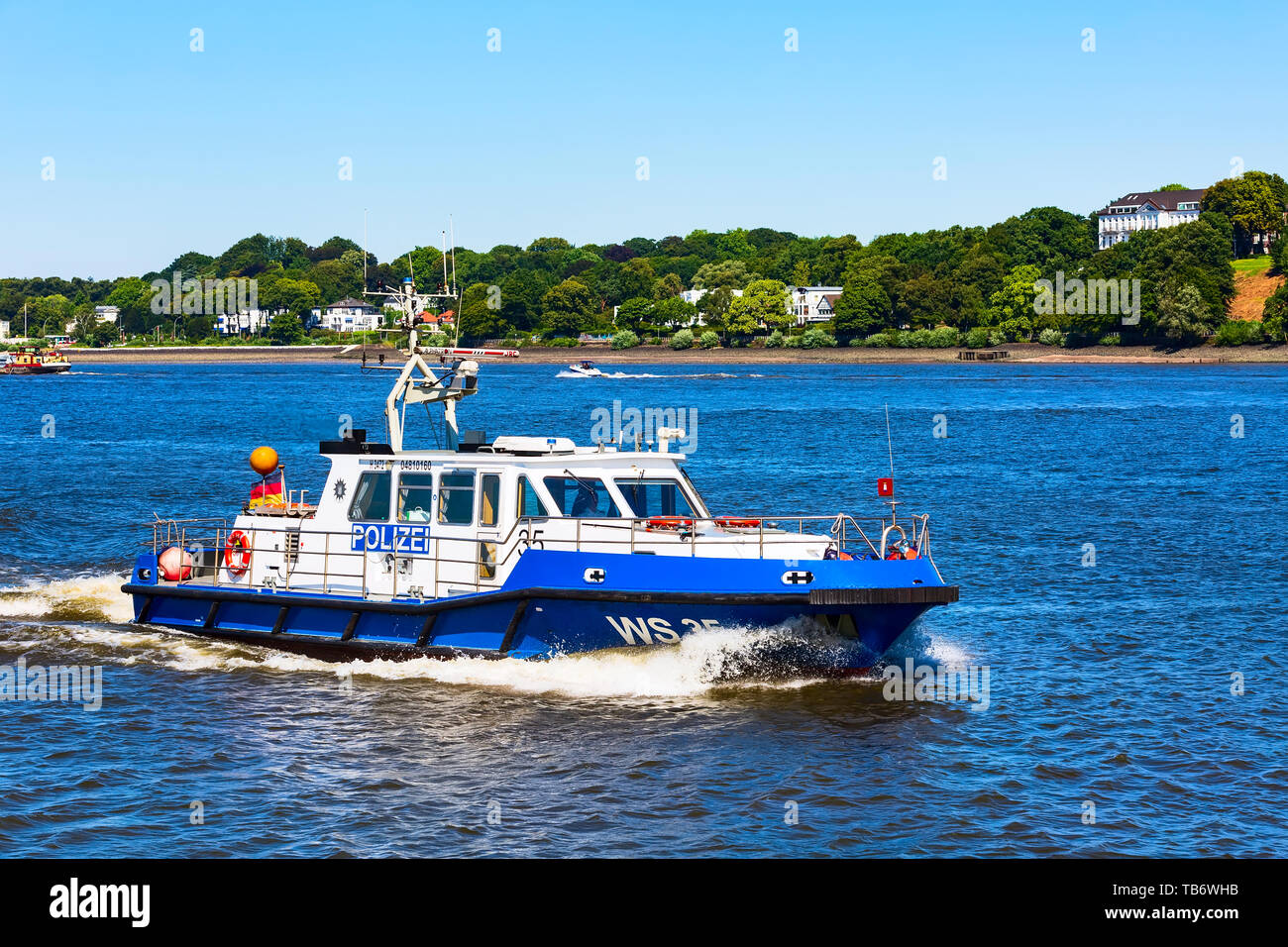 Hambourg, Allemagne - 26 juillet 2018 : bateau de police sur l'Elbe et maisons on riverbank Banque D'Images