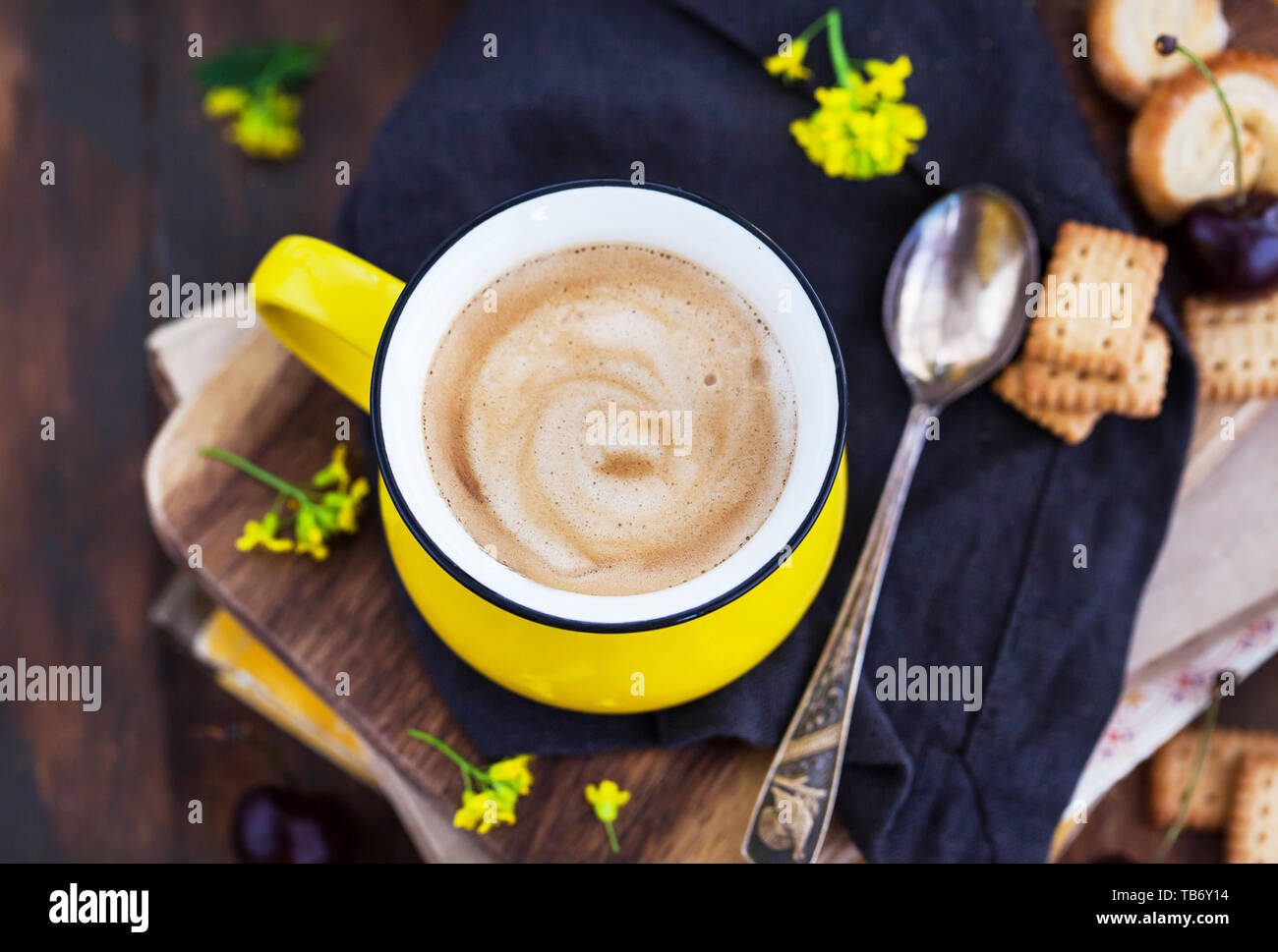 Mug jaune vif de douce chaude du café noir et des bonbons sur fond rustique d'été Banque D'Images