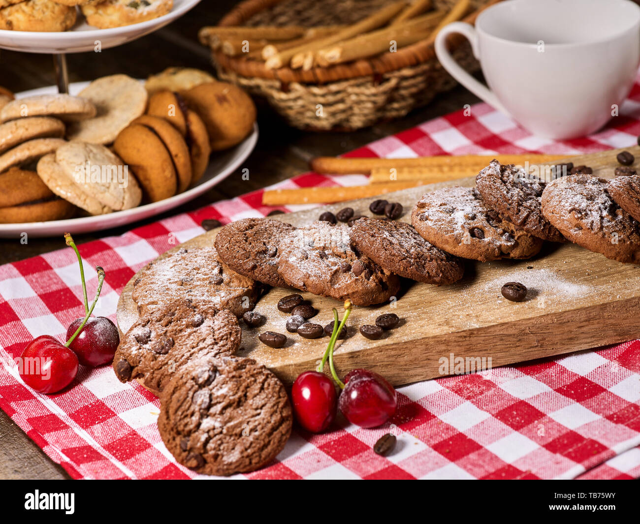 Les cookies au chocolat à l'avoine avec des grains de café et de cerise. Serveur Sun flare Banque D'Images
