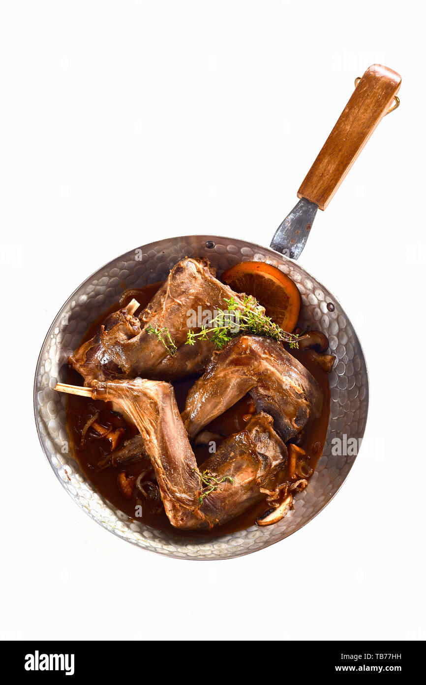 Rôti de lapin sauvage chevreuil aux champignons et d'origan ou de thym frais servi dans une sauce riche dans une casserole dans une vue du haut vers le bas isolated on white Banque D'Images