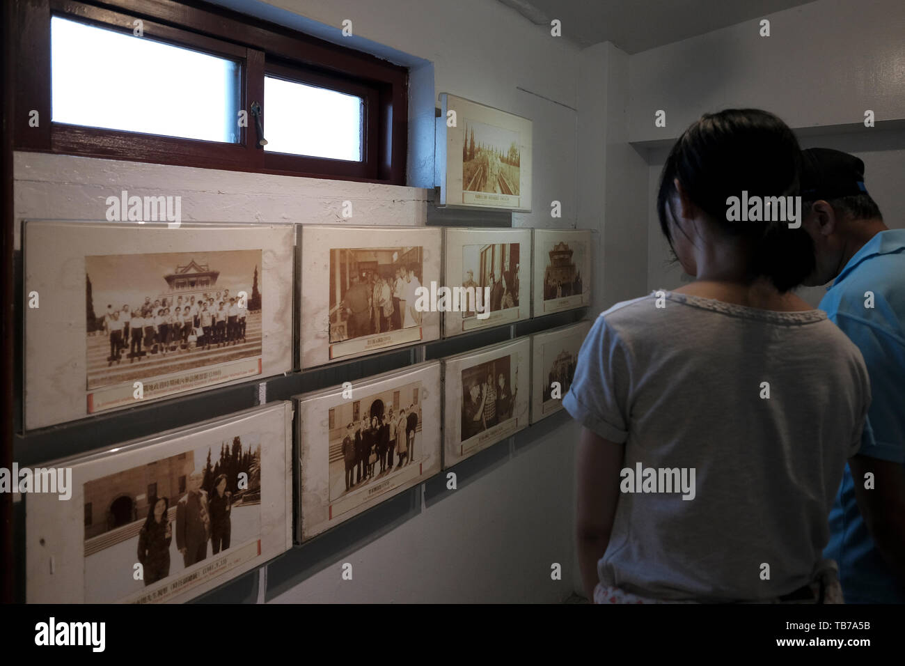 Les visiteurs regardant de vieilles photographies exposées à la galerie culturelle exposant des documents et des matériaux sur l'histoire et le statut actuel de Kinmen à l'intérieur de la tour Juguang construite en 1953 avec un style chinois traditionnel symbolisant l'histoire turbulente de Kinmen dans le canton de Jincheng, comté ou île de Kinmen, Taiwan Banque D'Images