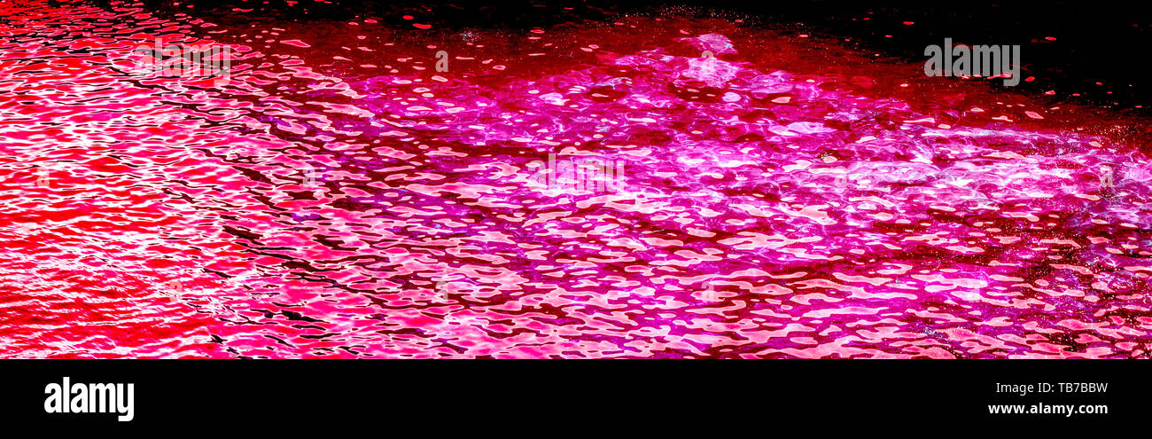 Photo horizontale de l'eau de rose, fuchsia, magenta, rouge de couleur avec la lumière du soleil reflétant. Banque D'Images