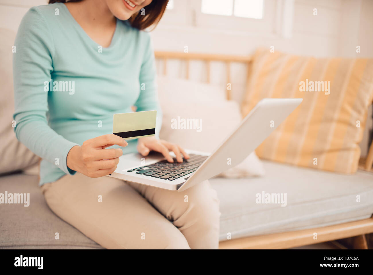 La clientèle féminine acheter des biens dans un magasin d'Internet, en utilisant une carte de crédit pour faire des achats en ligne à la maison Banque D'Images
