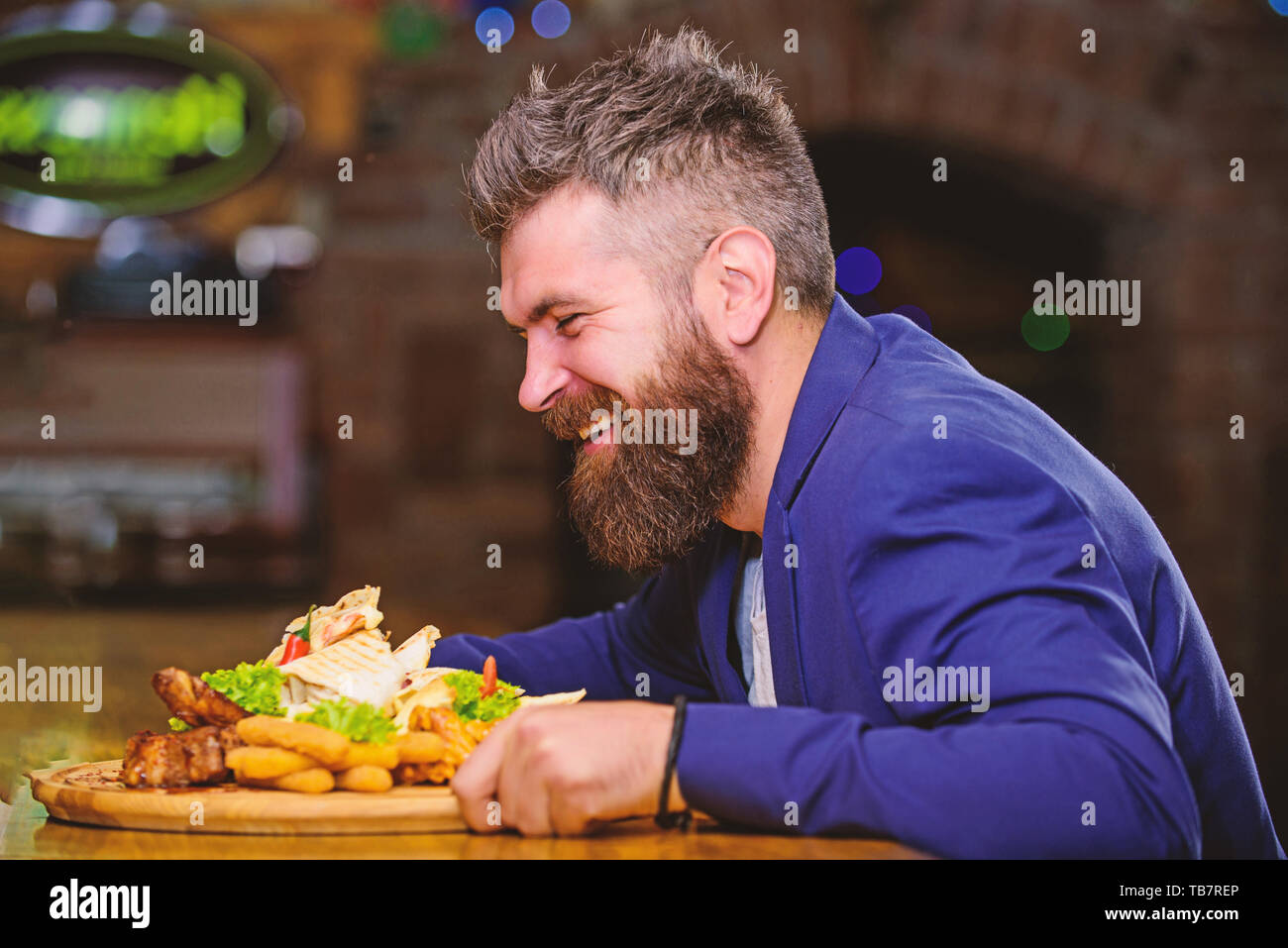 Hipster faim manger pub aliments frits. Costume officiel Gestionnaire de siéger au comptoir du bar. Délicieux repas. L'homme a reçu de pommes de terre frites repas avec les bâtonnets de poisson viande. Des calories. Profitez de repas. Tricher repas. Banque D'Images