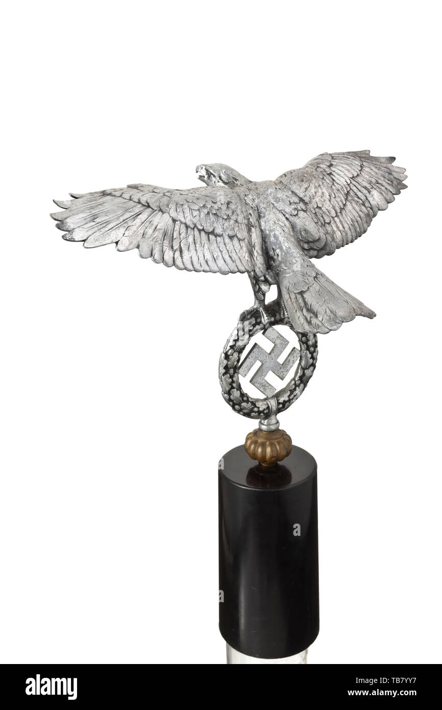 Un grand eagle pour un Johnny, tintement de forgé en aluminium poli. L'aigle en relief avec superbe ailes, tenant la couronne de feuilles de chêne d'une croix gammée dans ses serres. Une boule aplatie en métal non ferreux vissé sur la partie inférieure (partie de la Johnny grelots). Sur un socle en pierre noires assorties. Une fissure à la base de l'aile gauche, montrant des signes de vieillissement. Envergure ca. 55 cm, hauteur sans socle ca. 35 cm, hauteur totale ca. 56 cm. La grande version d'une partie extrêmement rares de la Wehrmacht équipement., historique du 20e siècle, Editorial-Use historique seule Banque D'Images