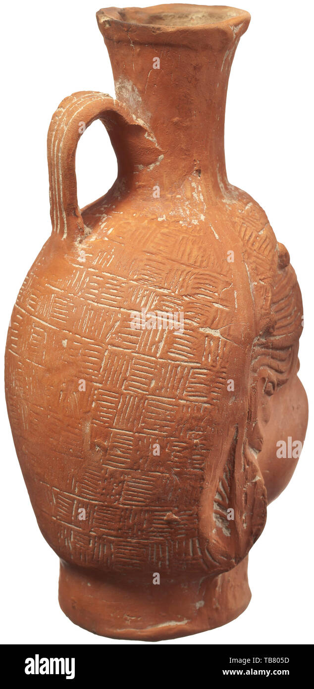Une terre sigillée romaine verseuse en la forme d'une femme chef, vers 290 - 320 A.D, céramique d'Afrique du Nord de plusieurs pièces moulées, faites à l'atelier 'Navigius' du nom d'un potter dans le centre de la Tunisie qui a fabriqué ces populaires articles d'exportation. Avec la tête d'une femme, la coiffure typique de l'arrière de la tête avec un voile décoré avec un motif à damiers, incisé. D'une ca. 6 cm de haut, légèrement élargir lèvre renforcé avec bec sur la tête. Poignée avec quatre flûtes sur l'épaule de la verseuse. Derrière l'oreille un moule vertical seam. Outre un minimum d'Additional-Rights Clearance-Info-chipping,-Not-Available Banque D'Images