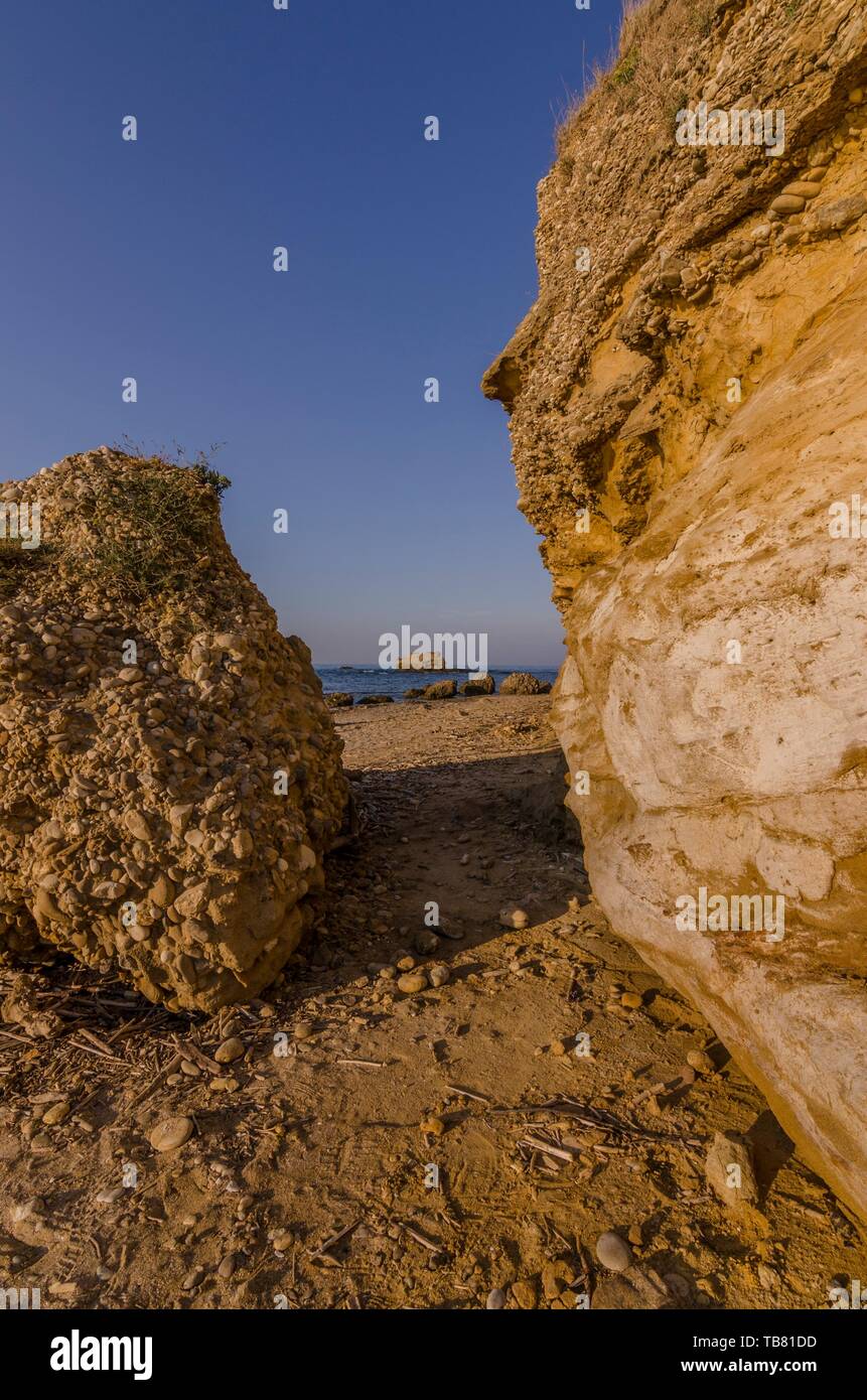 Le passage entre les rochers sur la plage de sable Banque D'Images