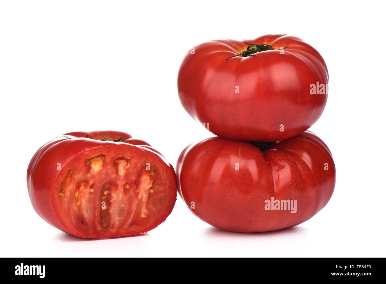 Trois grosses tomates mûres avec des gouttes d'eau isolé sur fond blanc.. Couper la tomate. Close up. Copy space Banque D'Images