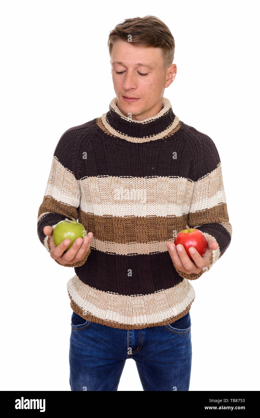 Studio shot of young handsome Young man holding green et pomme rouge isolé contre fond blanc Banque D'Images