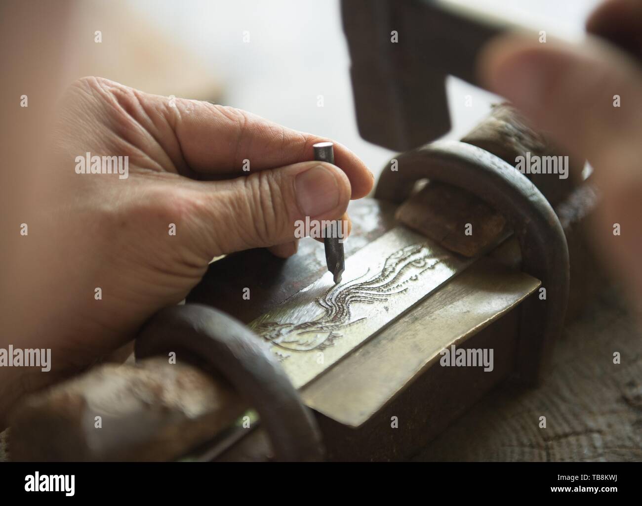 (190531) -- BEIJING, 31 mai 2019 (Xinhua) -- Zheng Guorong sculpte patten d'un phénix sur l'Épée Épée en 8090 au studio de l'est de la Chine, Longquan Zhejiang Province, le 21 mai 2019. Pendant des siècles, Longquan a été célèbre pour son épée. Zheng Guorong, 55, un patrimoine culturel immatériel de l'héritière dans Longquan sabre, épée a fait depuis plus de 30 ans. Zheng ce qui concerne l'épée comme un symbole de l'esprit et consacre toute sa carrière avec admiration. Dans son studio, l'ensemble du processus de décisions d'une seule épée prend de deux à trois mois, avec des étapes suivantes, y compris la formation d'une idée, de la conception de la Banque D'Images