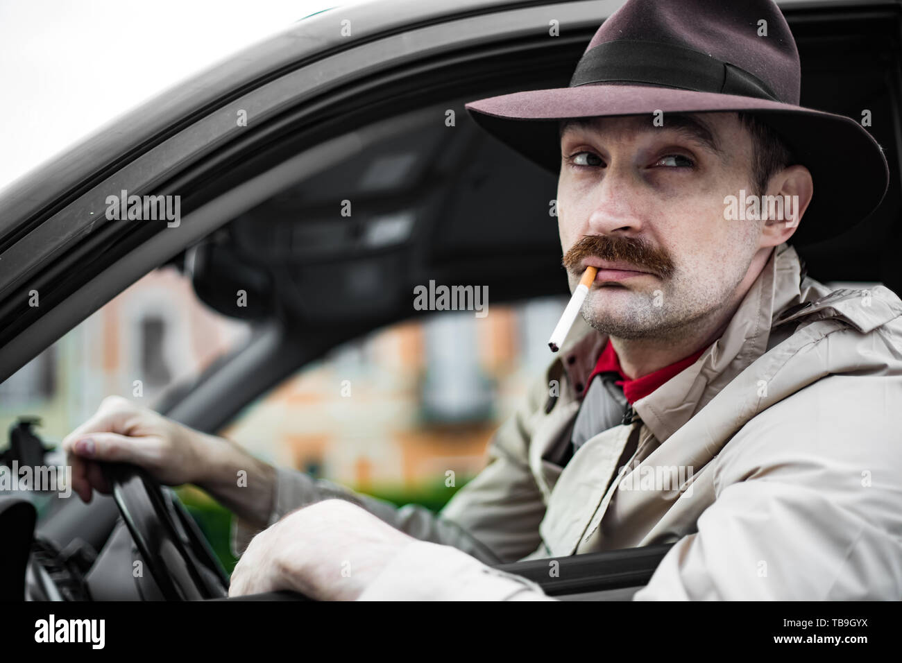 Detective fumer une cigarette dans sa voiture en harcelant Banque D'Images