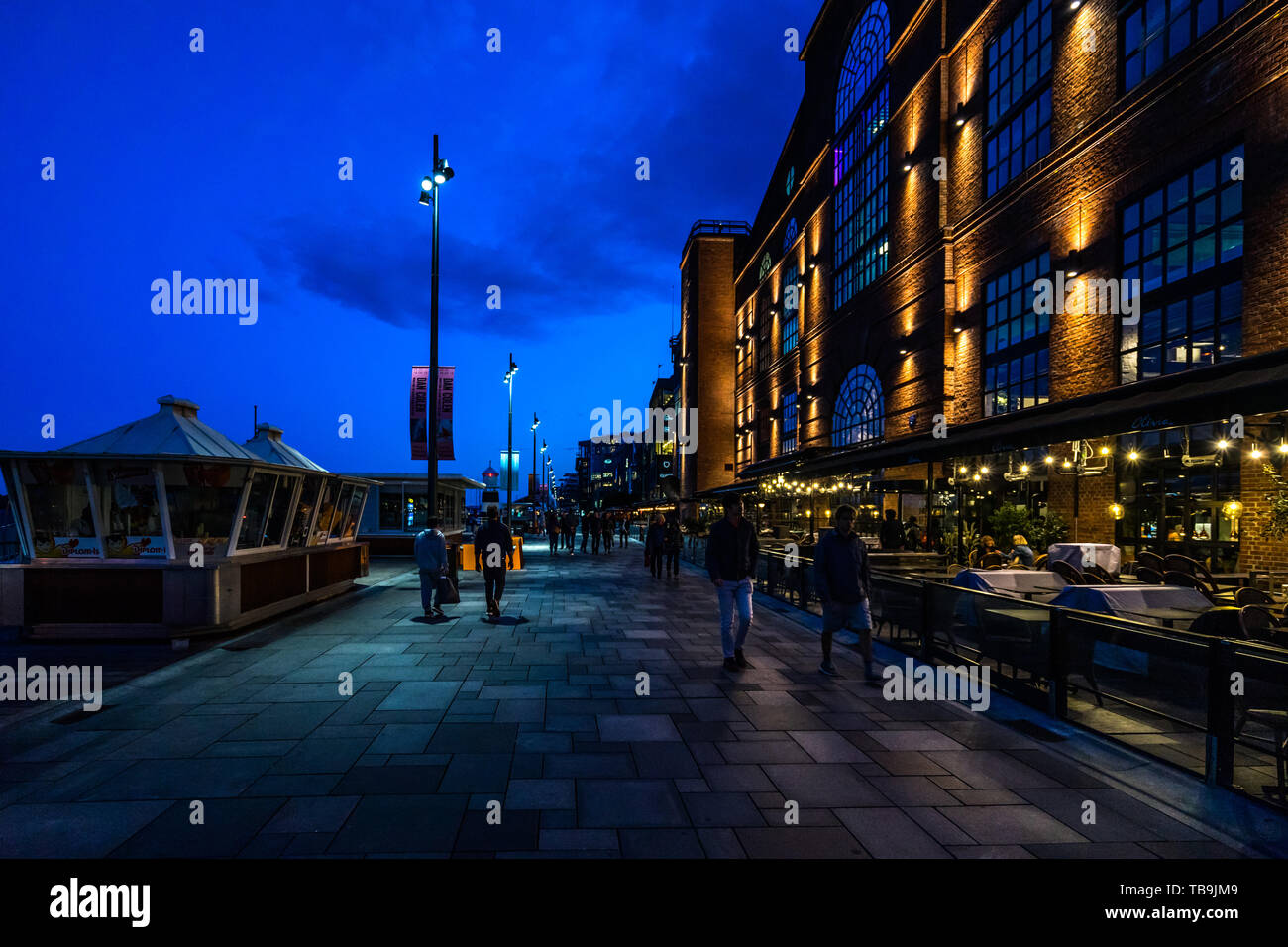 Vue de nuit sur la promenade au bord de l'Aker Brygge plein de bars et restaurants, Oslo, Norvège Banque D'Images