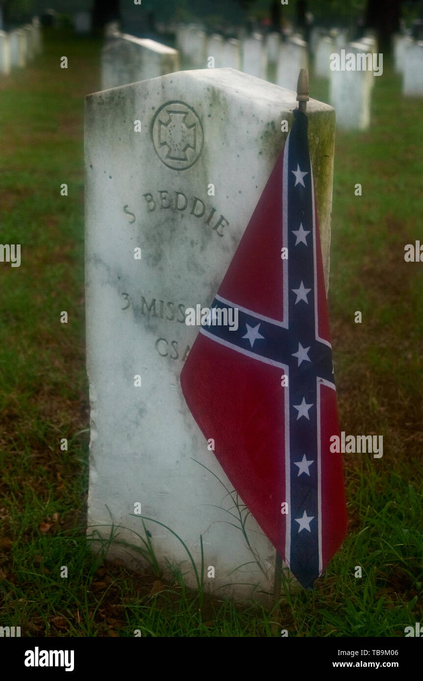Un drapeau confédéré décore la tombe d'un ancien combattant de la guerre civile en début d'après-midi brumeux, dans l'Amitié Cemetery à Columbus, Mississippi. Banque D'Images