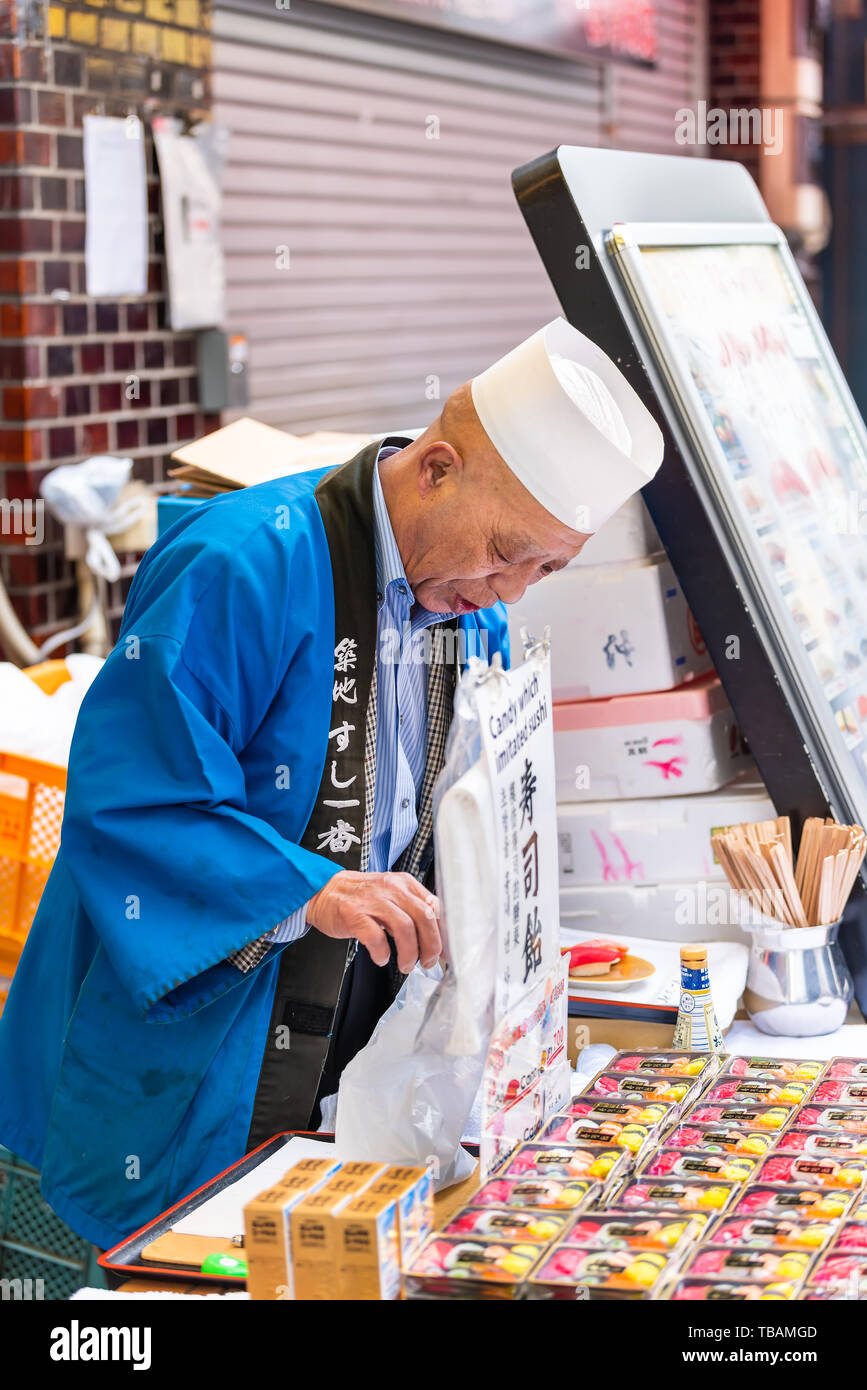 Tokyo, Japon - 30 mars 2019 : marché de Tsukiji extérieur près de Ginza avec homme libre du vendeur de vendre des bonbons sushi on street Banque D'Images
