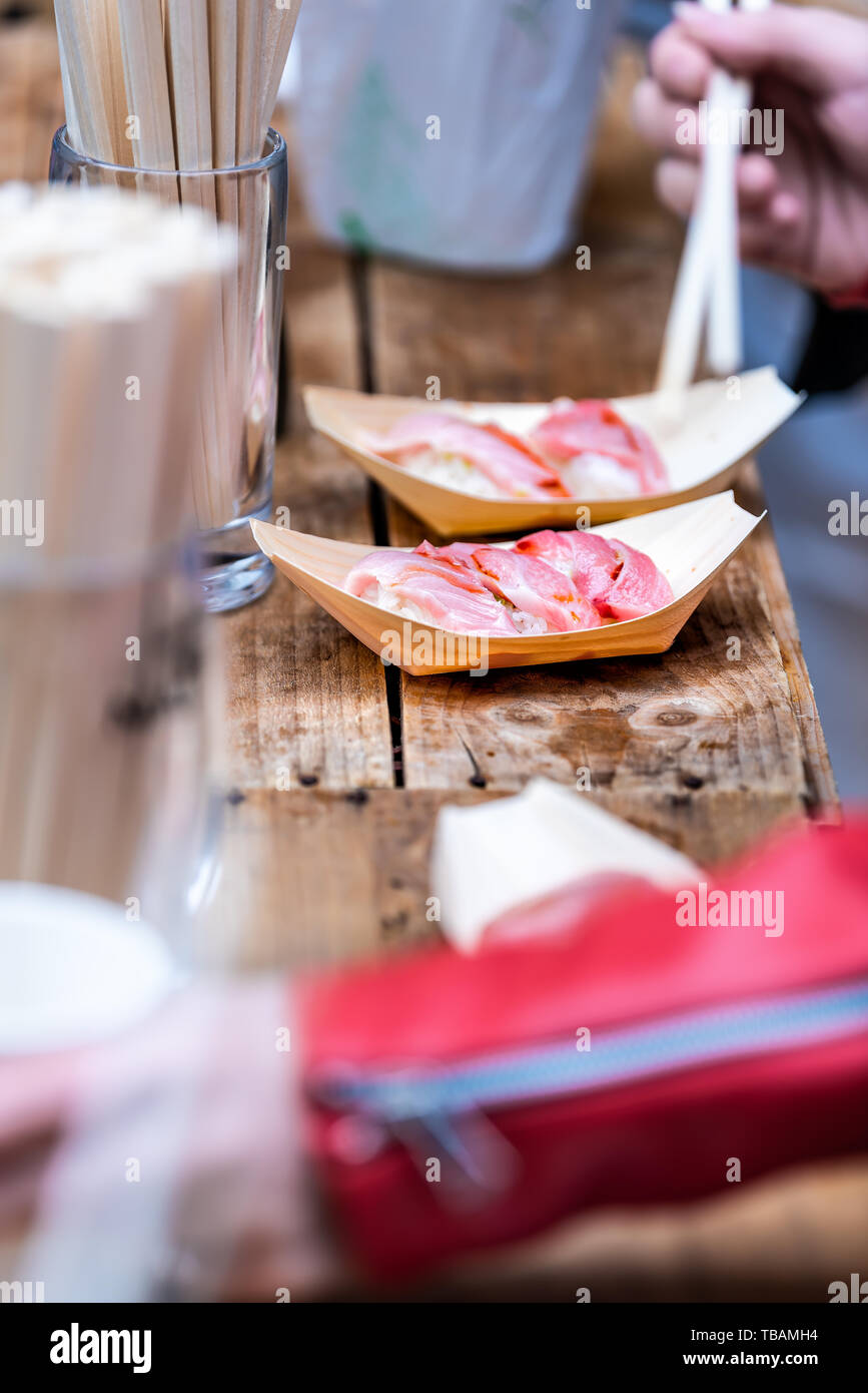 Tokyo, Japon l'rue du marché de Tsukiji dans Ginza avec des gens libre de manger des sushis sashimis avec des baguettes sur la table à l'extérieur Banque D'Images