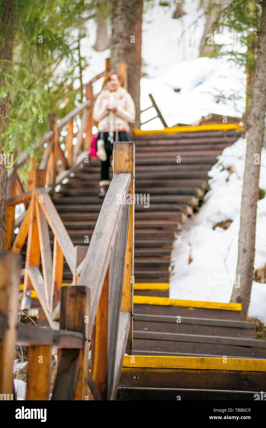 Sur le chevalet en bois route dans la forêt de sapins à l'endroit pittoresque Dazhuhai Holiday Tianshan en hiver, un touriste, c'est marcher dans les étapes Banque D'Images