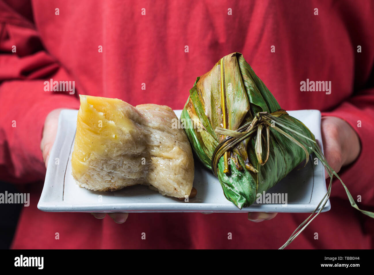 Une femme donne zongzi (rice dumpling) à d'autres comme un présent sur Dragon Boat Festival asiatique,la nourriture traditionnelle, Banque D'Images