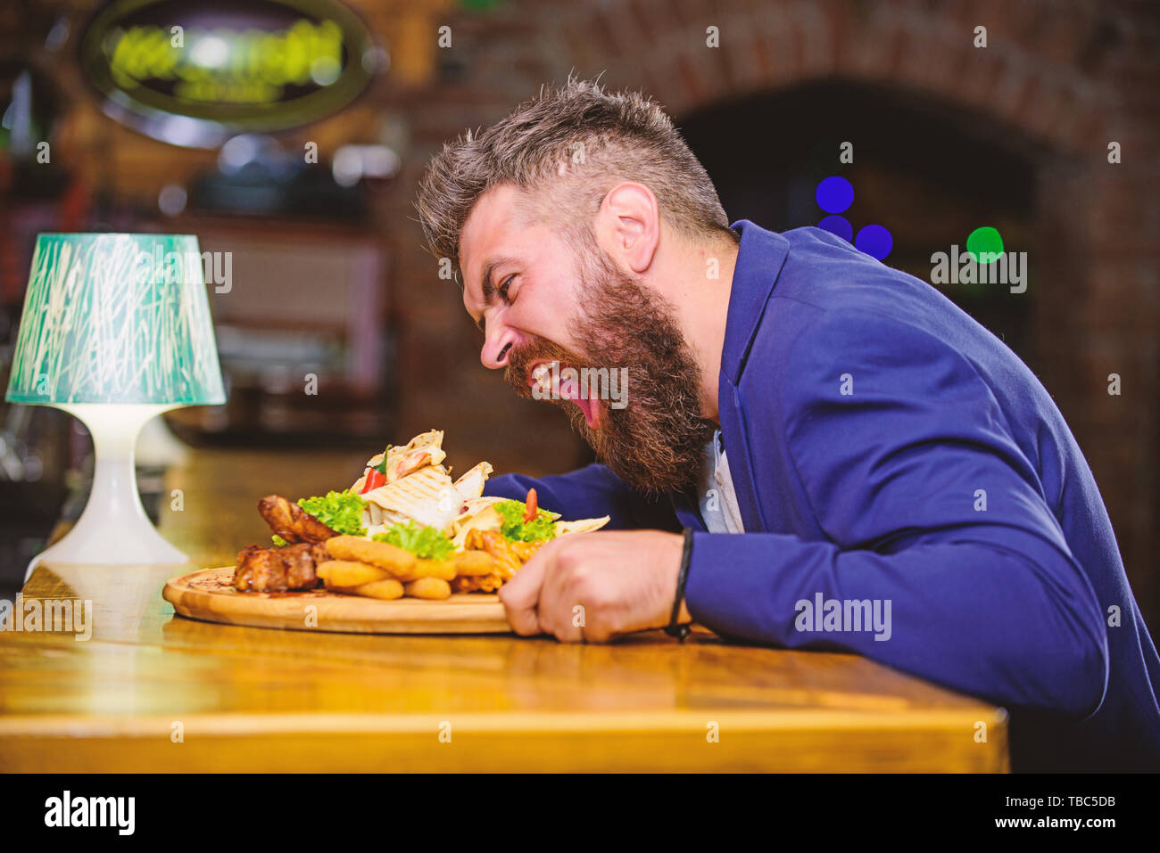 Tricher repas. Hipster faim manger pub aliments frits. Costume officiel Gestionnaire de siéger au comptoir du bar. Délicieux repas. L'homme a reçu de pommes de terre frites repas avec les bâtonnets de poisson viande. Des calories. Profitez de repas. Banque D'Images