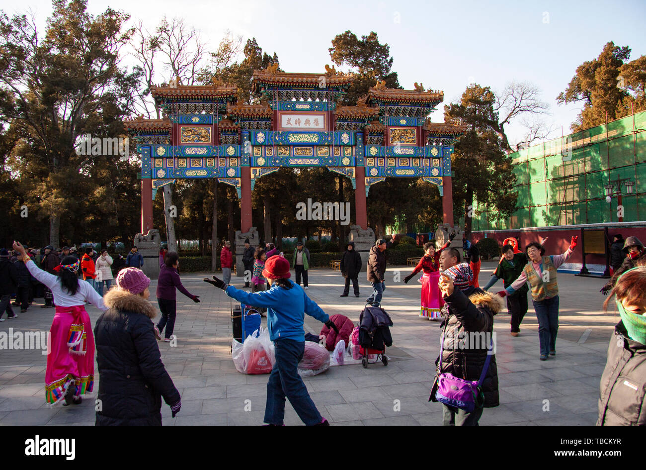 La danse du peuple chinois par un Paifang Archway dans une place publique dans un parc à Pékin, en Chine. Beijing, Chine - le 21 décembre 2014. Banque D'Images