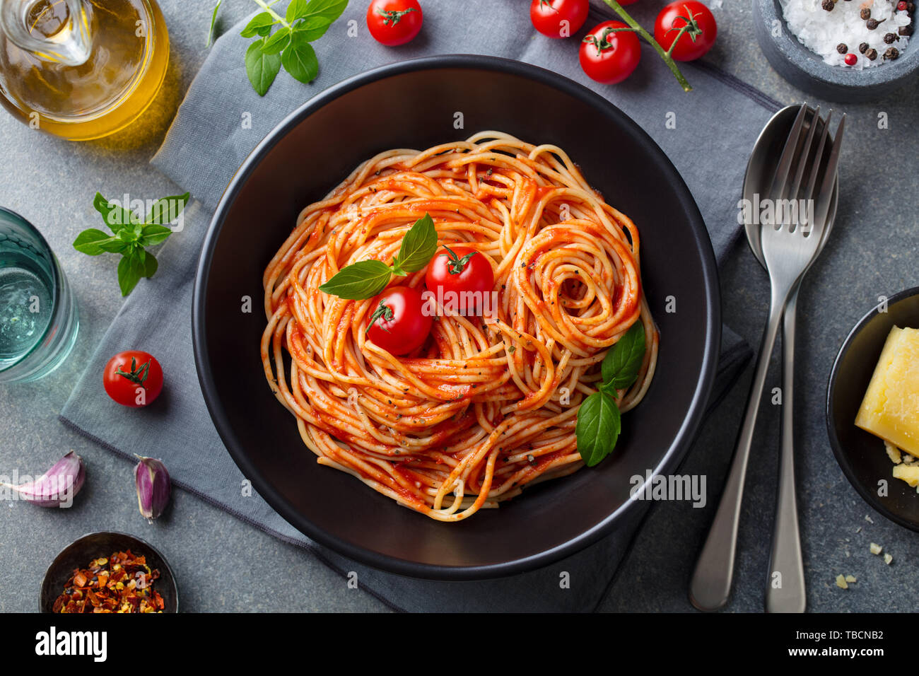 Les pâtes, spaghetti à la sauce tomate dans un bol noir sur fond noir en gris. Vue d'en haut. Banque D'Images