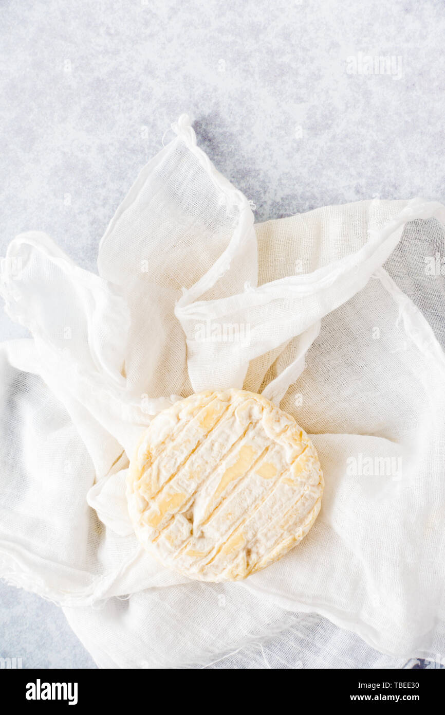 Vue de dessus du fromage de chèvre rond blanc sur fond texturé et chiffon musulmane avec copie espace. Banque D'Images