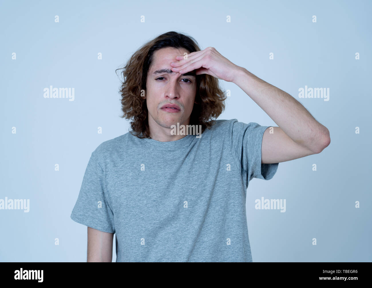 Jeune adolescent à la peur et réfléchie qui souffrent de migraines dans de grandes souffrances. Portrait de milliers d'homme dans la douleur émotionnelle. En soin du expressi Banque D'Images