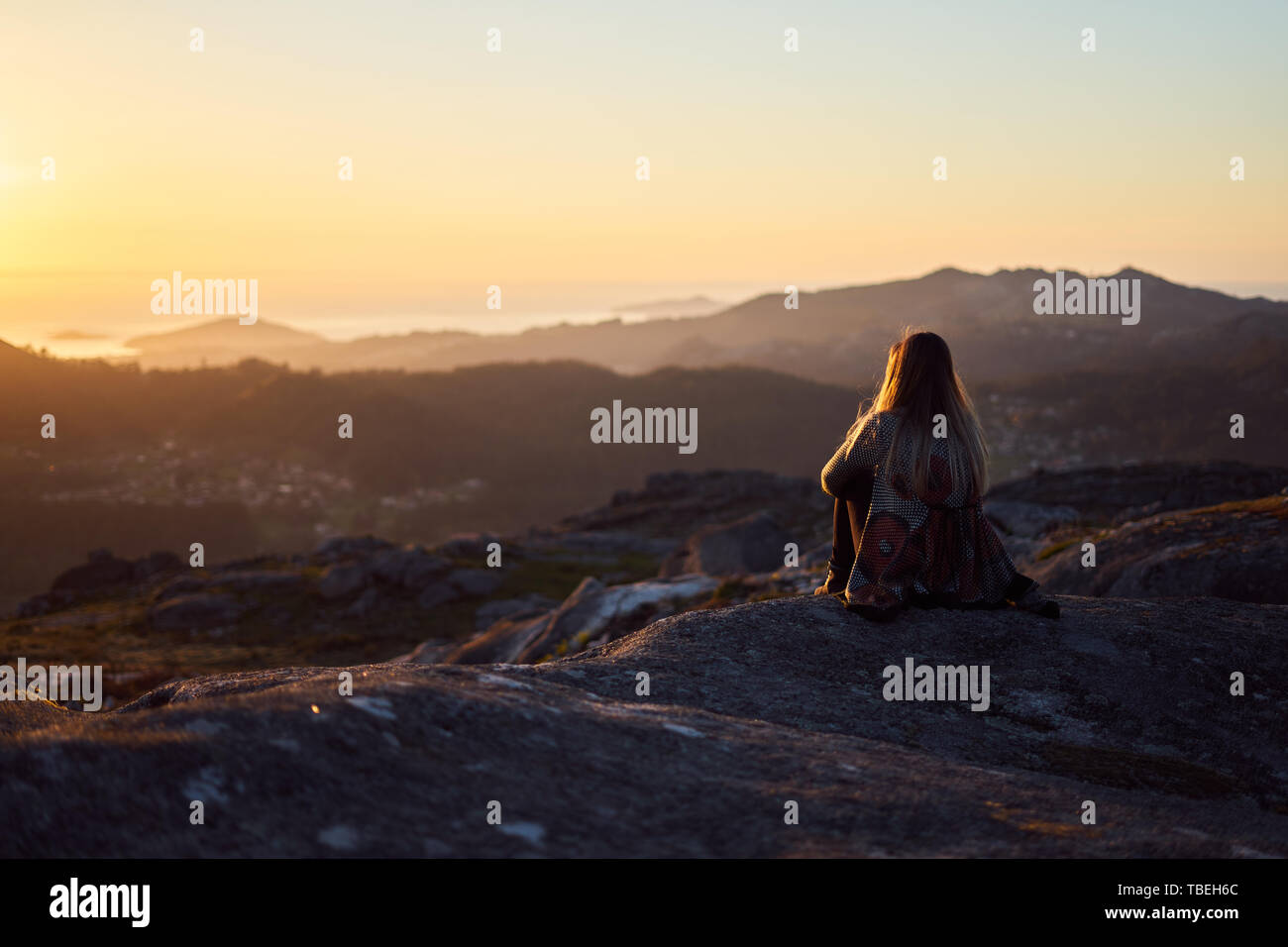 Jeune femme contemplant le coucher de soleil depuis le mont Galiñeiro à Vigo, Galice, Espagne Banque D'Images