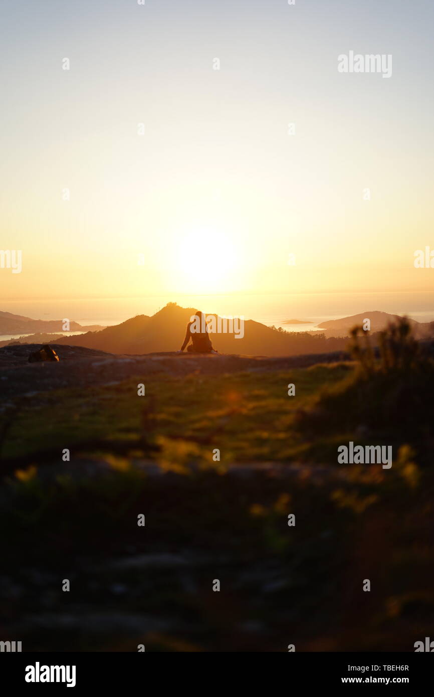 Jeune femme contemplant le coucher de soleil depuis le mont Galiñeiro à Vigo, Galice, Espagne Banque D'Images
