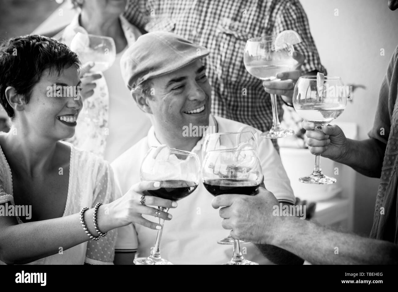 Le noir et blanc l'amitié personnes concept avec couple et amis ensemble toasting et acclamer avec du vin rouge et de cocktails - concept célébration wi Banque D'Images