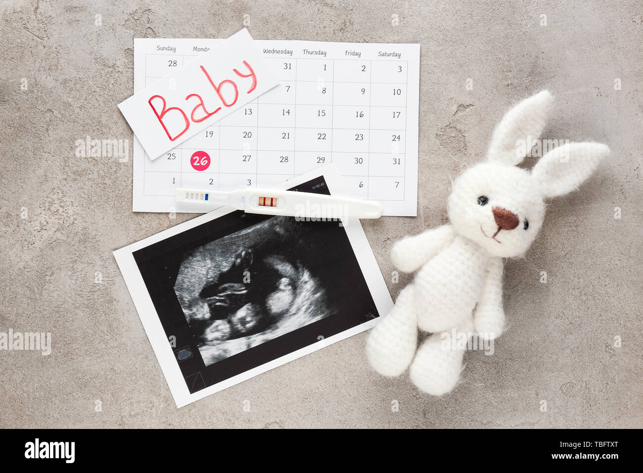 Sonogramme image, test de grossesse, calendrier et jouet sur fond gris Banque D'Images