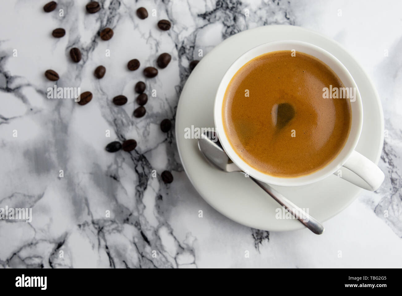 Vue de dessus d'une délicieuse et savoureuse tasse de café fraîchement préparé avec des fèves de café Banque D'Images