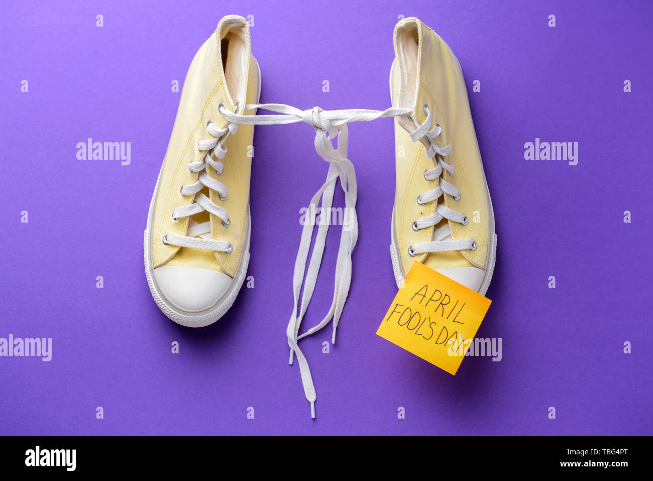 Chaussures à lacets attachés ensemble et sticky note avec texte Poisson d' avril sur un fond de couleur Photo Stock - Alamy