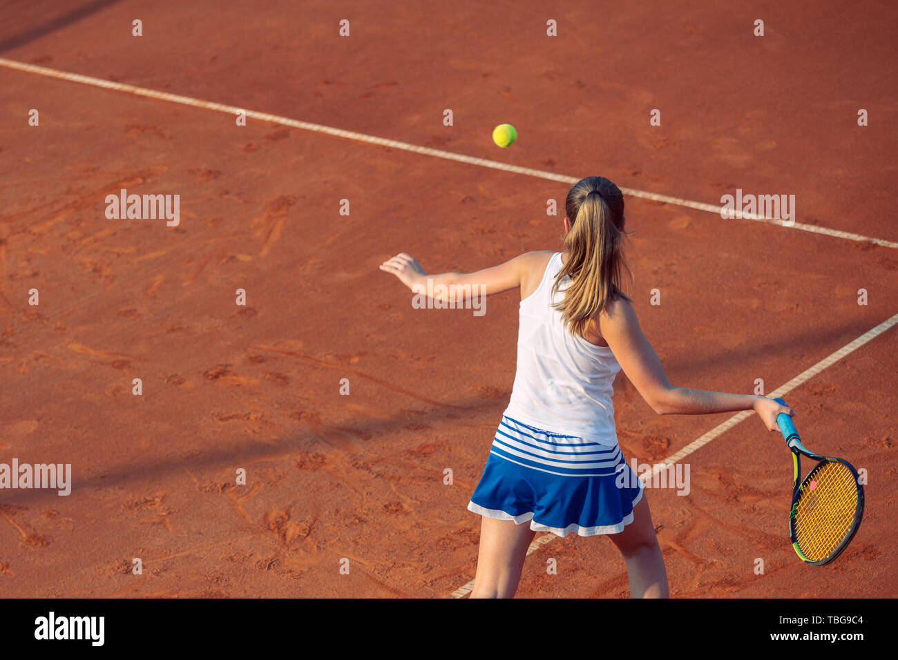 Jeune femme jouant au tennis sur terre battue. Du coup droit. Banque D'Images