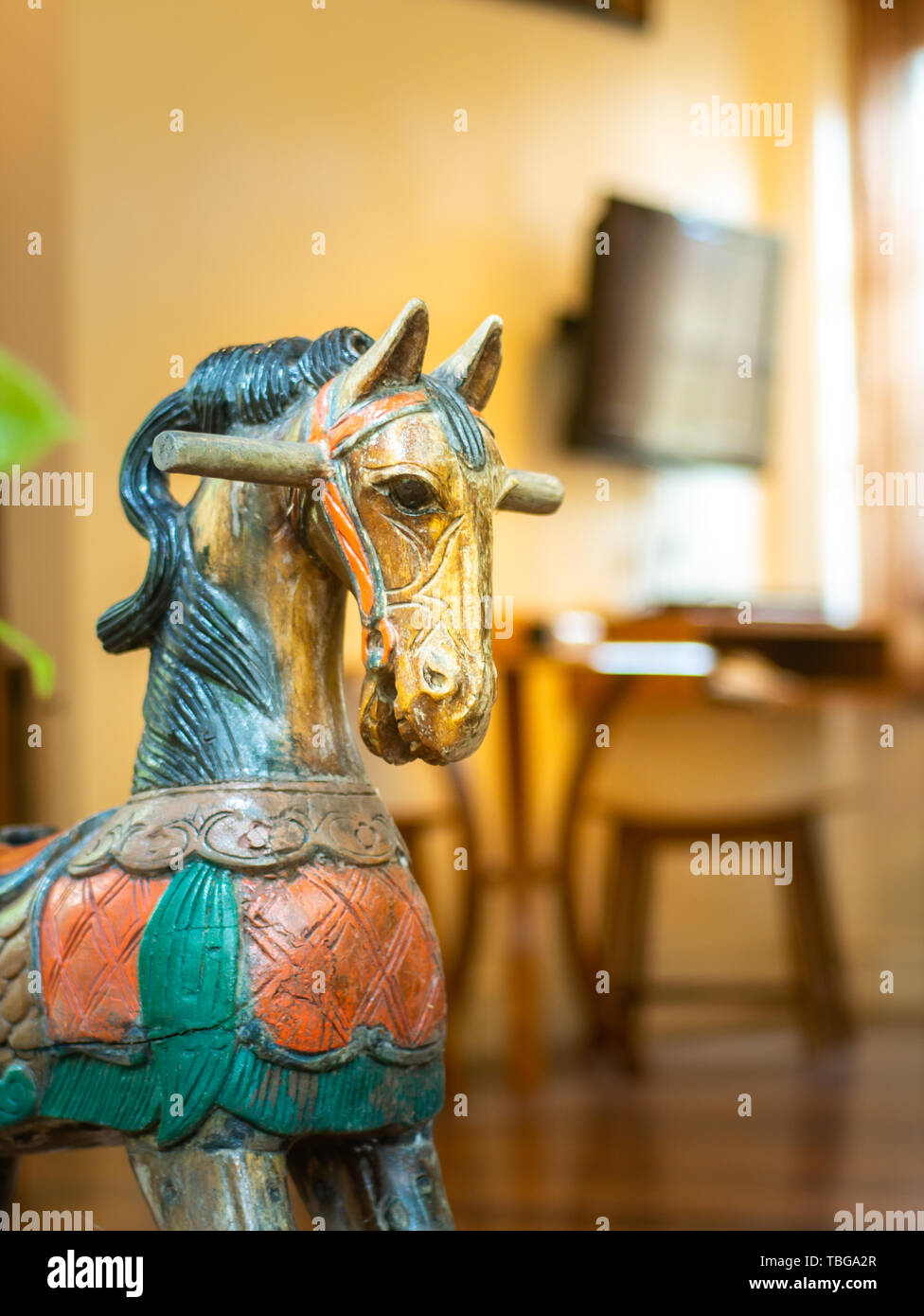 Cheval en bois sculpté ancien décoré en face de la chambre avec la lumière wam. Banque D'Images