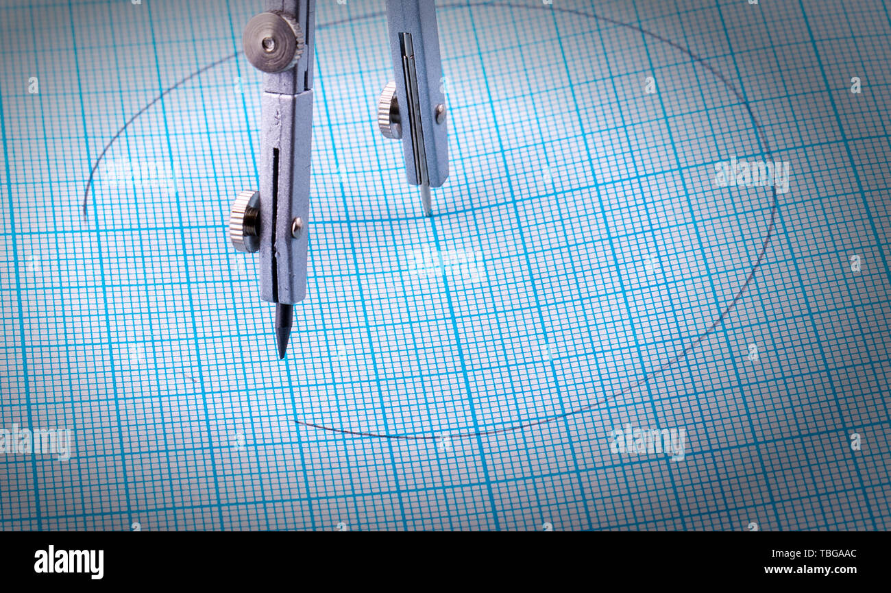 Compassescompasses et un cercle peint sur papier quadrillé bleu Banque D'Images
