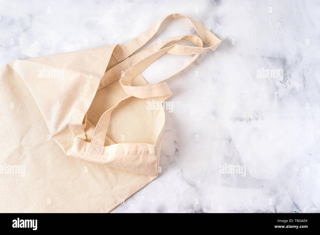 Sac en tissu blanc sur fond de ciment. Vue d'en haut Banque D'Images