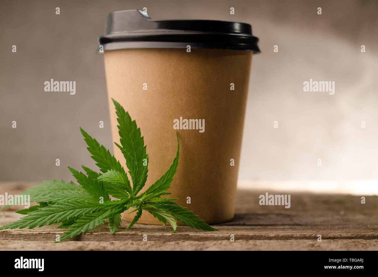 Tasse à café avec du papier vert et de feuilles de cannabis contre le bois l'arrière-plan. Thème coffee shop aux Pays-Bas. Banque D'Images