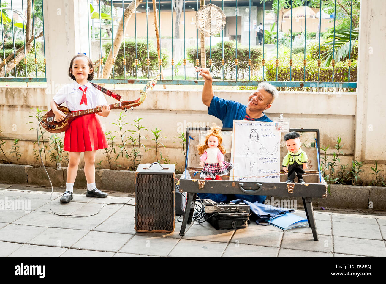 Un mignon petit Thai girl effectue au public en jouant de sa guitare à Bangkok en Thaïlande. Banque D'Images