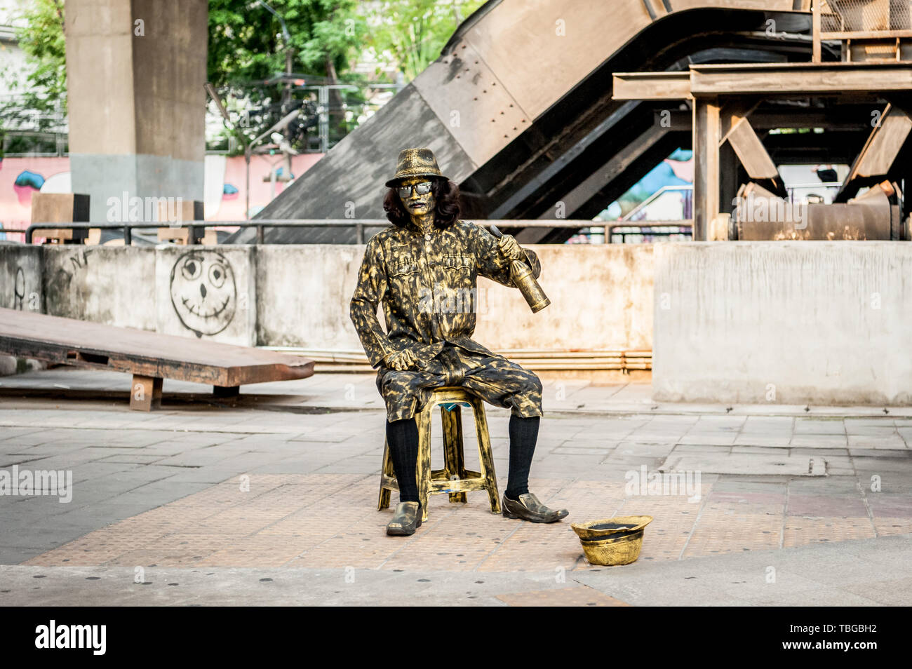 Un jeune garçon thaïlandais pose comme une statue humaine à Bangkok, Thaïlande dans le cadre de l'animation de rue. Banque D'Images