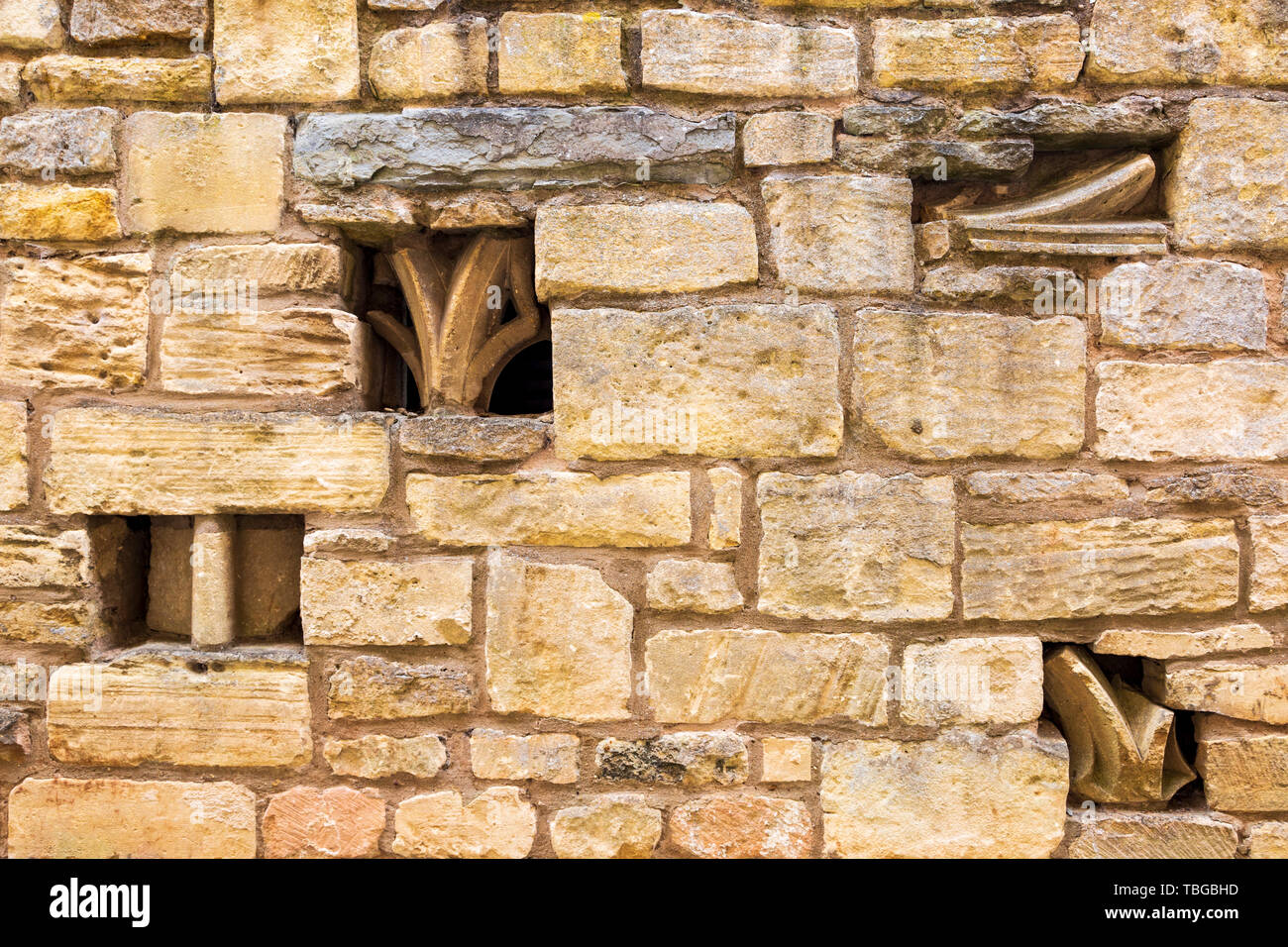 Pierre de l'église de fragments d'ornement intégré dans un mur en pierre de Cotswold Banque D'Images