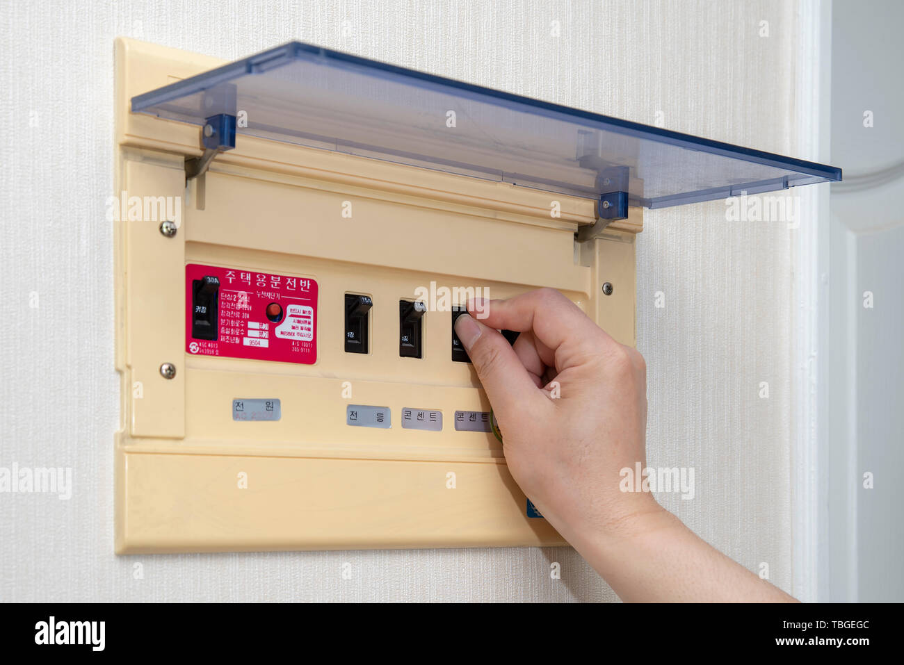 L'électricien sur disjoncteur ouvre la main. Concept de sécurité électrique. Banque D'Images