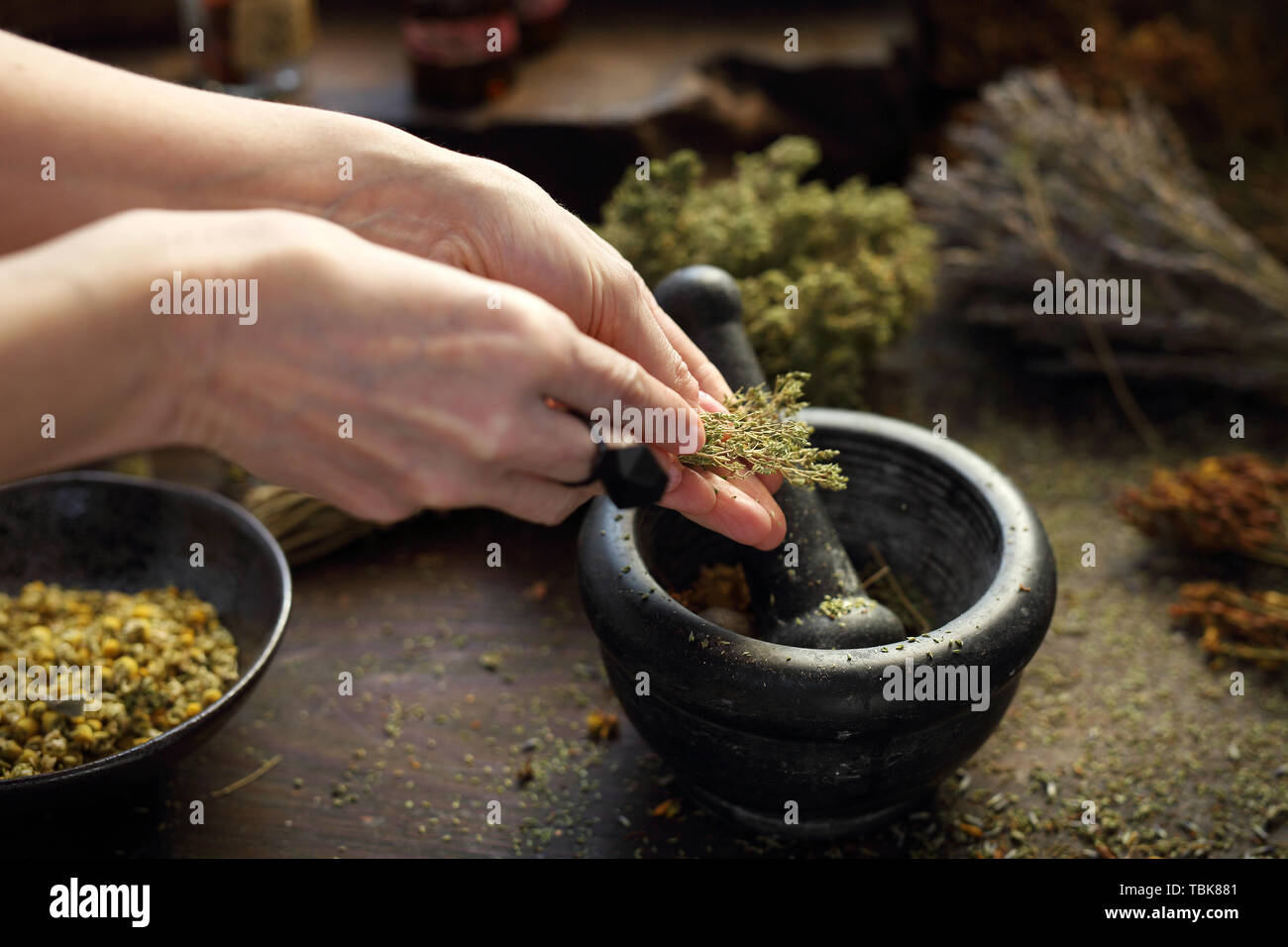Herboriste. La femme prépare les mélanges à base de plantes médicinales. Il compose les herbes par broyage dans un mortier Banque D'Images