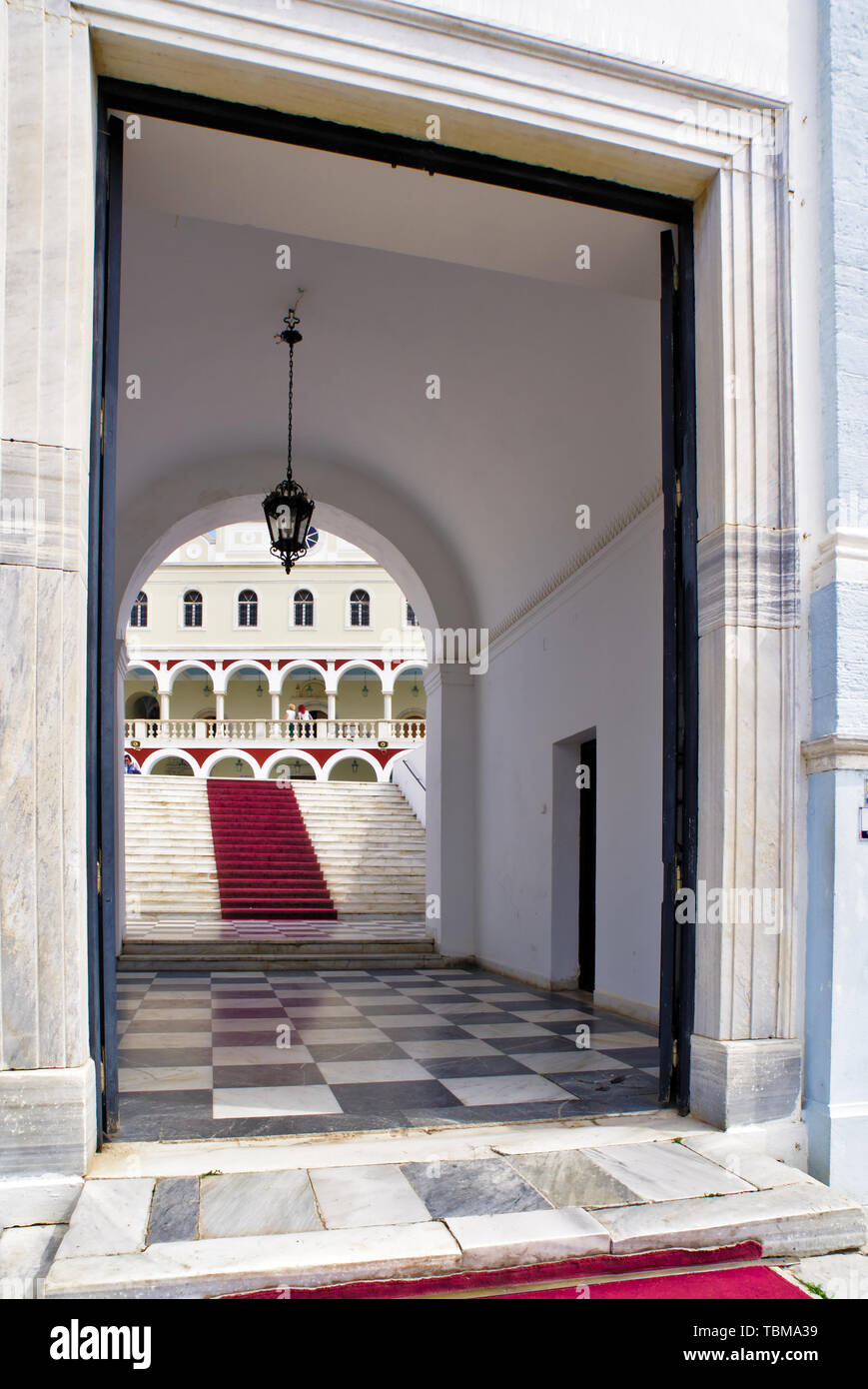 L'Église chrétienne orthodoxe de la Vierge Marie à l'ile de Tinos, Grèce, l'entrée principale, un escalier avec tapis rouge et motif carré noir et blanc marbre. Banque D'Images