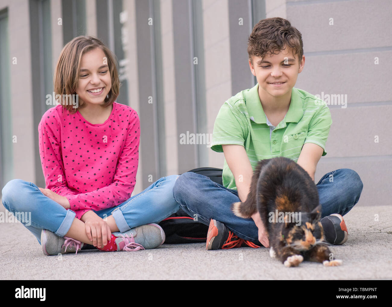 Garçon et fille avec cat en plein air Banque D'Images