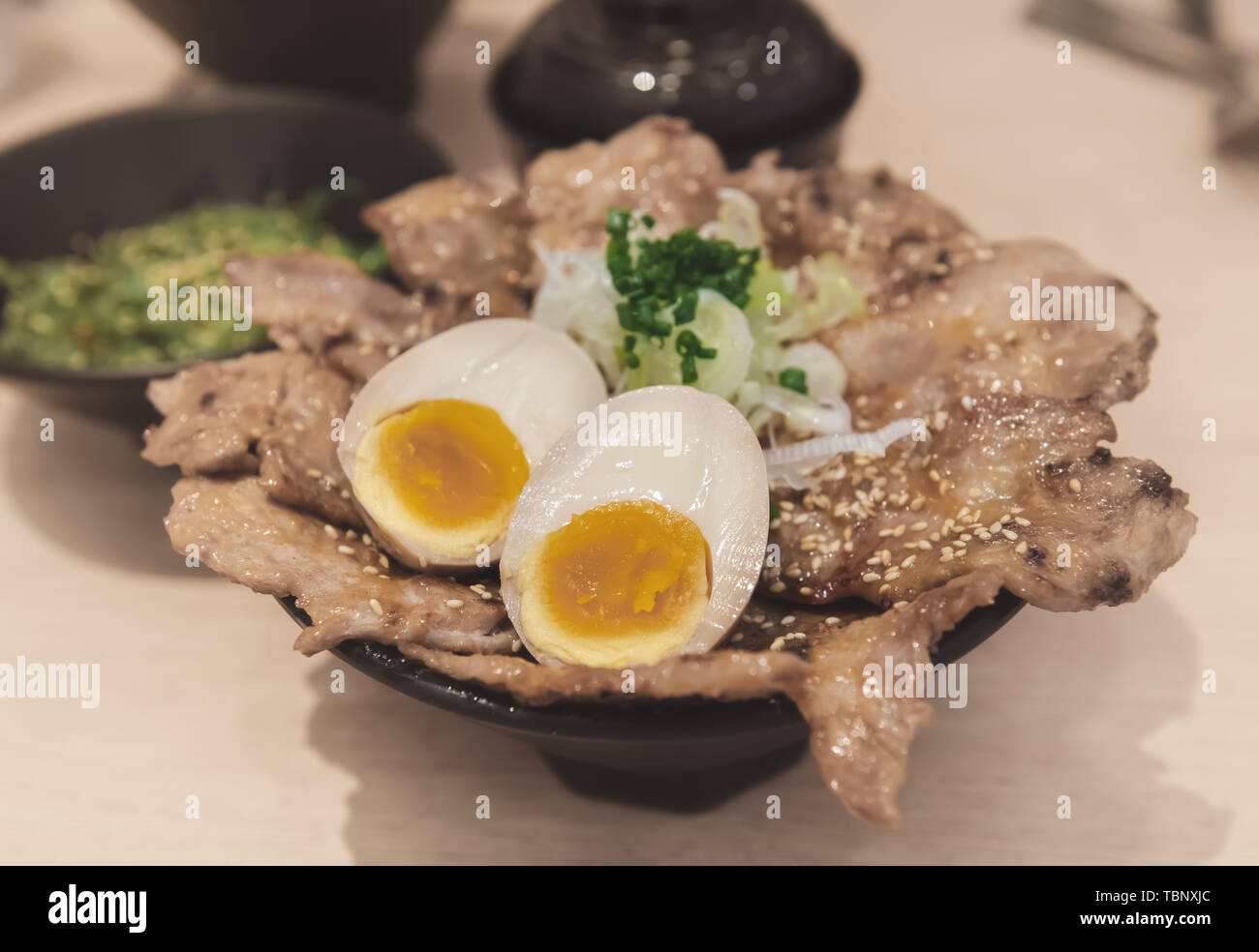 Tasse de riz avec le porc grillé et oeuf onzen dans le style japonais avec des aliments de faible éclairage intérieur. Banque D'Images