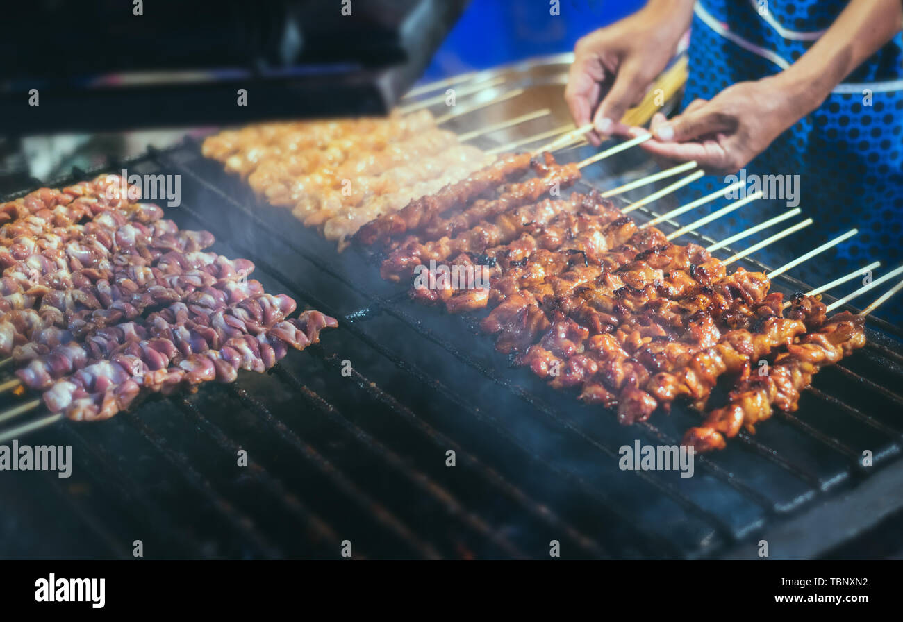 Brochette de poulet grillée avec le charbon de flamme dans l'alimentation de rue style avec ton de gris couleur appliquée. Banque D'Images