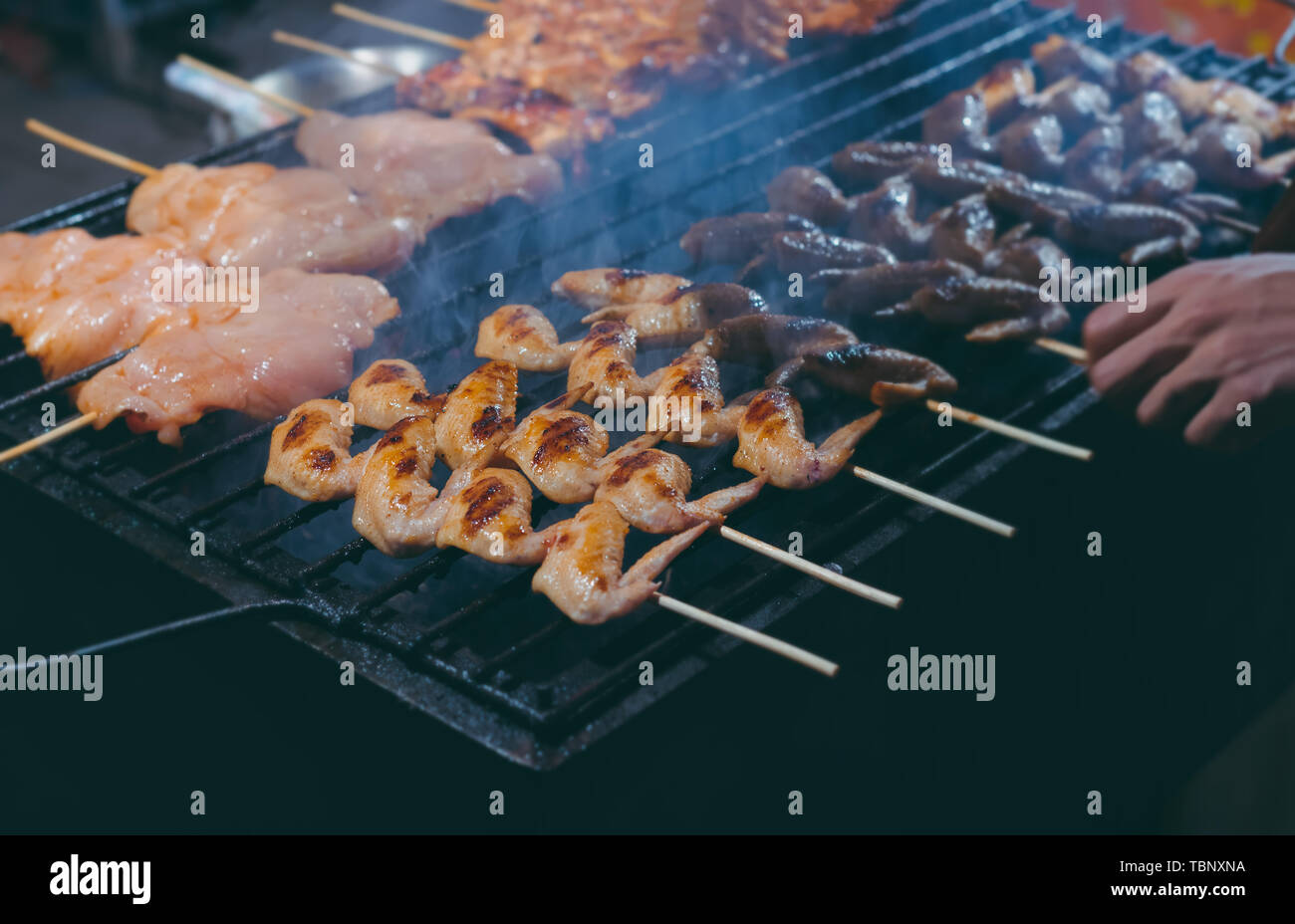Brochette de poulet grillée avec le charbon de flamme dans l'alimentation de rue style avec ton de gris couleur appliquée. Banque D'Images