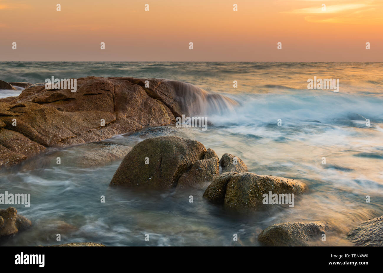 Le rocher et la mer lisse vague dans l'heure du coucher de soleil photo avec piscine et faible éclairage sombre paysage marin. Banque D'Images